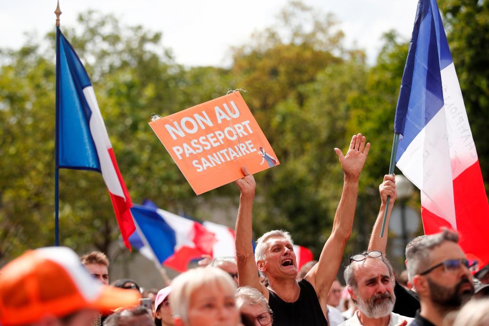 A protester holds a placard that reads No to the health passport during a demonstration called by the French nationalist party Les Patriotes (The Patriots) against France's restrictions to fight the coronavirus disease (Covid-19) outbreak, on the Droits de l'Homme (human rights) esplanade at the Trocadero Square in Paris, France, July 24, 2021.-Reuters