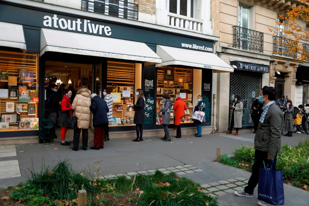People queue at the 'click and collect' service of bookshop Atout Livre in Paris as all non-essential stores are closed in France to combat the coronavirus disease (Covid-19) outbreak, France, November 21, 2020. — Reuters