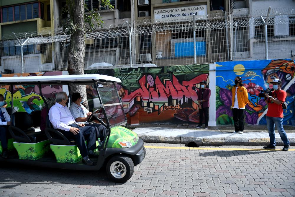Menteri Wilayah Persekutuan Tan Sri Annuar Musa melihat lukisan mural dan grafiti yang dihasilkan oleh para pelukis tempatan ketika hadir pada majlis penyampaian hadiah Pertandingan Mural dan Grafiti Transformasi Pasar Borong Kuala Lumpur di Pasar Borong Kuala Lumpur hari ini. — Bernama