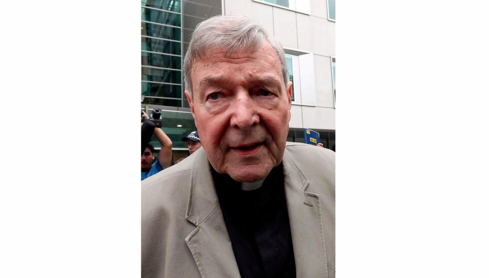 In this file photo taken on Feb 26, Cardinal George Pell (C) leaves the County Court of Victoria court after prosecutors decided not to proceed with a second trial on alleged historical child sexual offences in Melbourne. — AFP