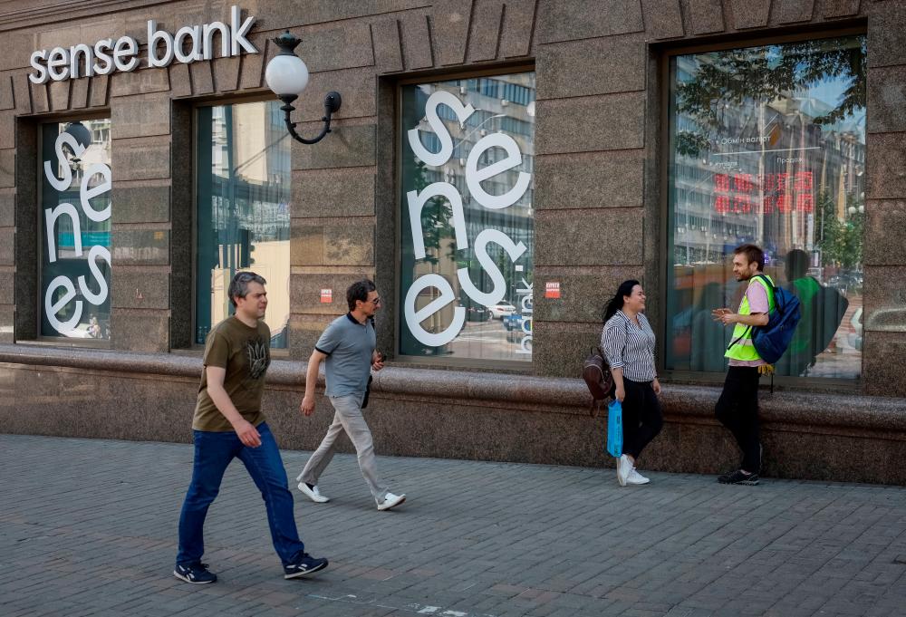 Pedestrians walking past a branch of Sense Bank in central Kyiv, Ukraine. – Reuterspic