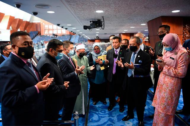 Seeking blessings... Prime Minister Tan Sri Muhyiddin Yassin (third from right) and members of the Cabinet recite a doa at the Parliament lobby yesterday. — Bernama
