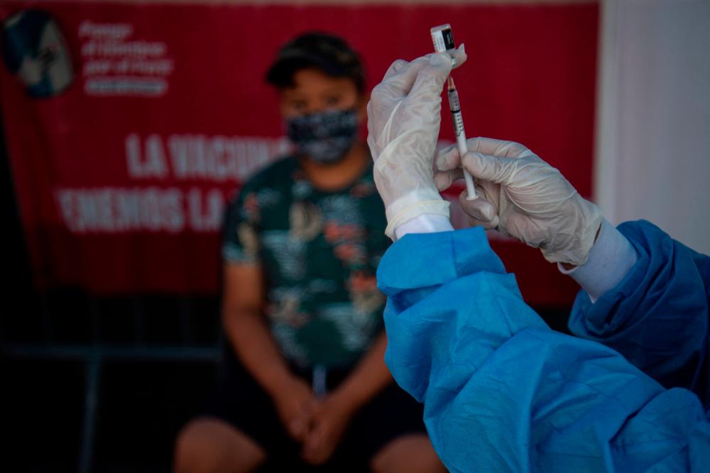 A health worker prepares to inoculate a child with a dose of the Pfizer-BioNTech vaccine against COVID-19 during a vaccination campaign in Lima, on January 25, 2022, amid the coronavirus pandemic. AFPPIX