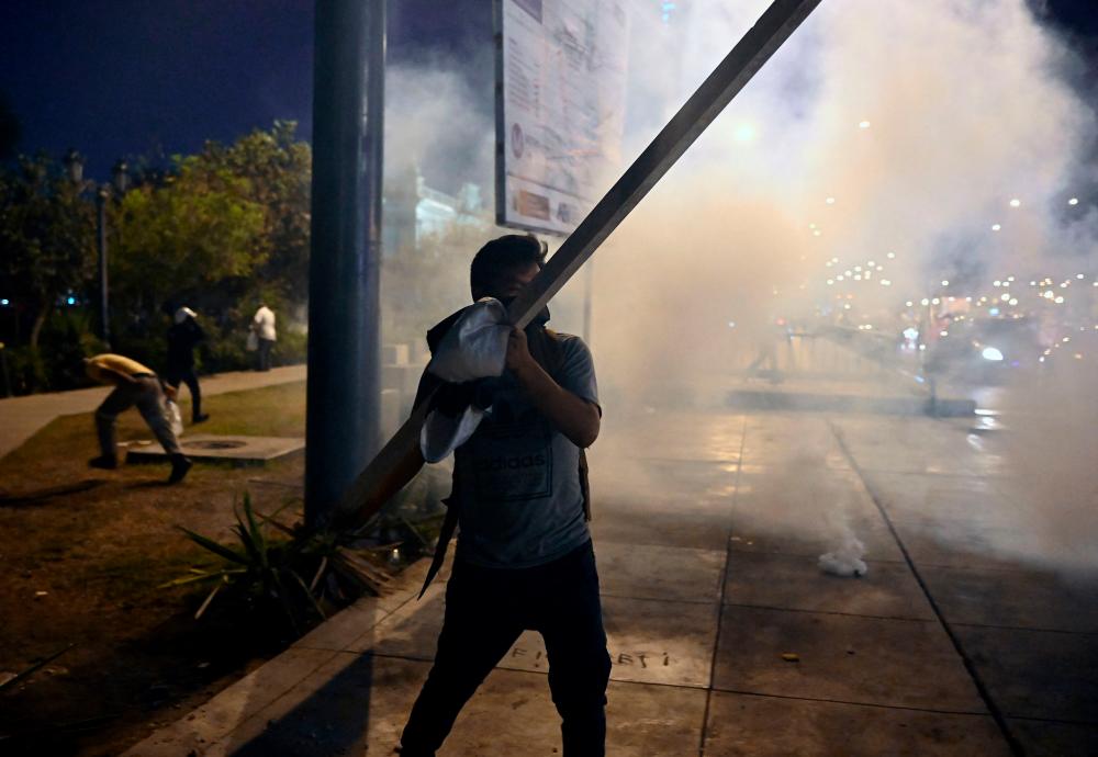 A demonstrator carries a pole during clashes with riot police within a protest demanding the resignation of Peru’s President Dina Boluarte in Lima on January 23, 2023. AFPPIX