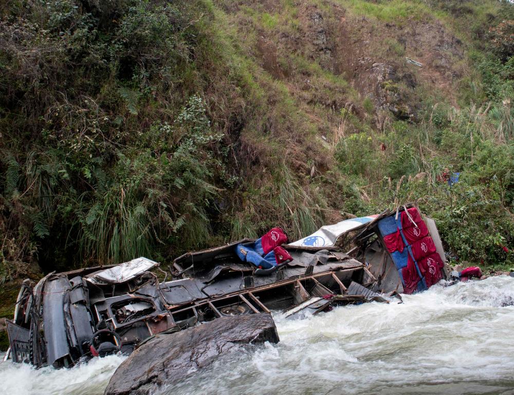 The wreckage of a passenger bus remains at the bottom of a ravine after plunging from a mountain road in the Andean region of Cajamarca, Peru, on April 29, 2024. - AFPPIX