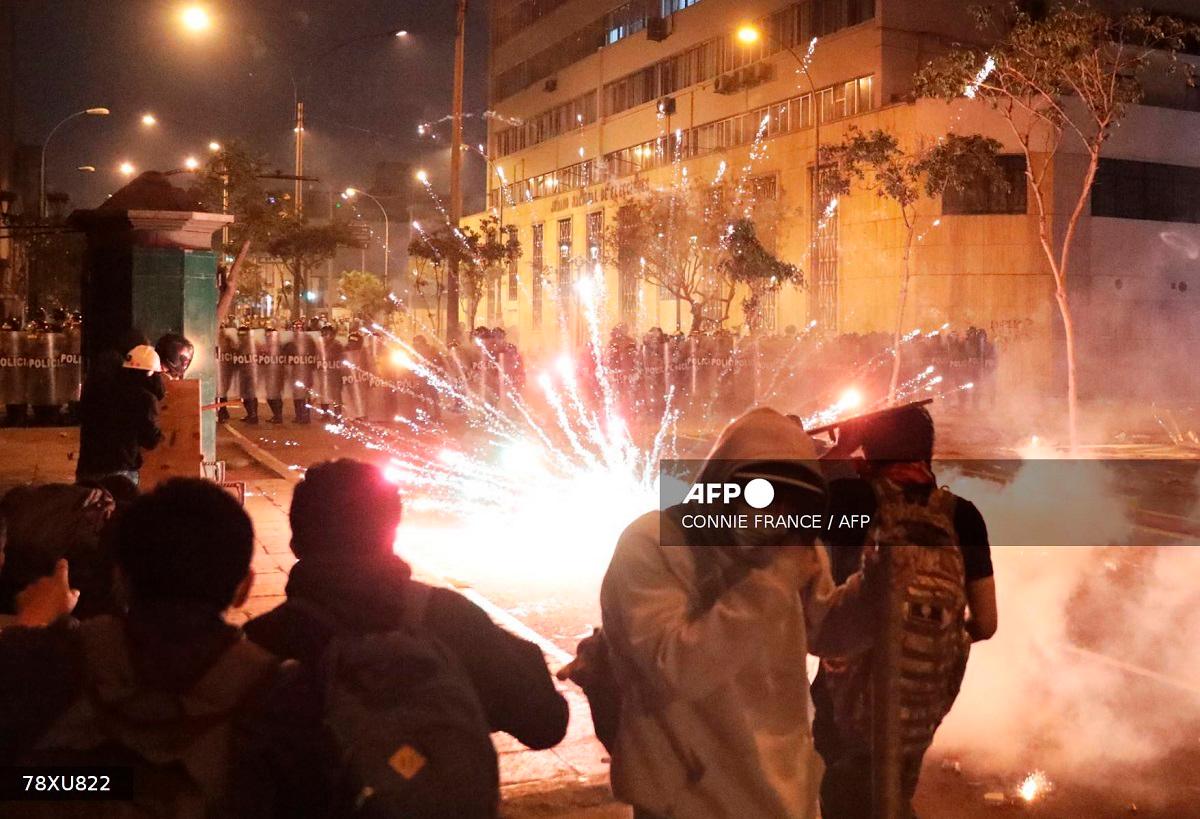 Demonstrators clash with anti-riot police officers during protest against Peru's interim President Jose Jeri in Lima on October 15, 2025. - CONNIE FRANCE / AFP