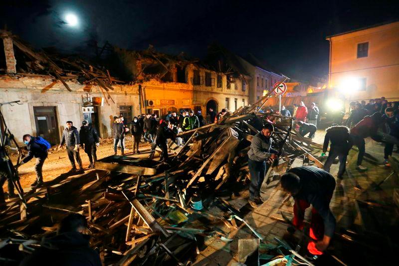 People clean debris from a street after an earthquake, in Petrinja, Croatia December 29, 2020. — Reuters