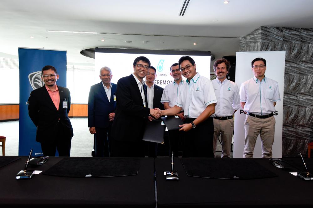 Ruslan (in white shirt) handing over agreement to Lim during the signing ceremony, witnessed by (from left) Yusri, Radzaif, Li, Syed Zainal Abidin, D’Arrigo and Wong.