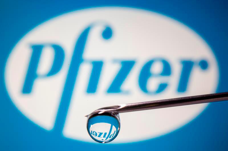 Pfizer’s logo is reflected in a drop on a syringe needle in this illustration taken November 9, 2020. — Reuters