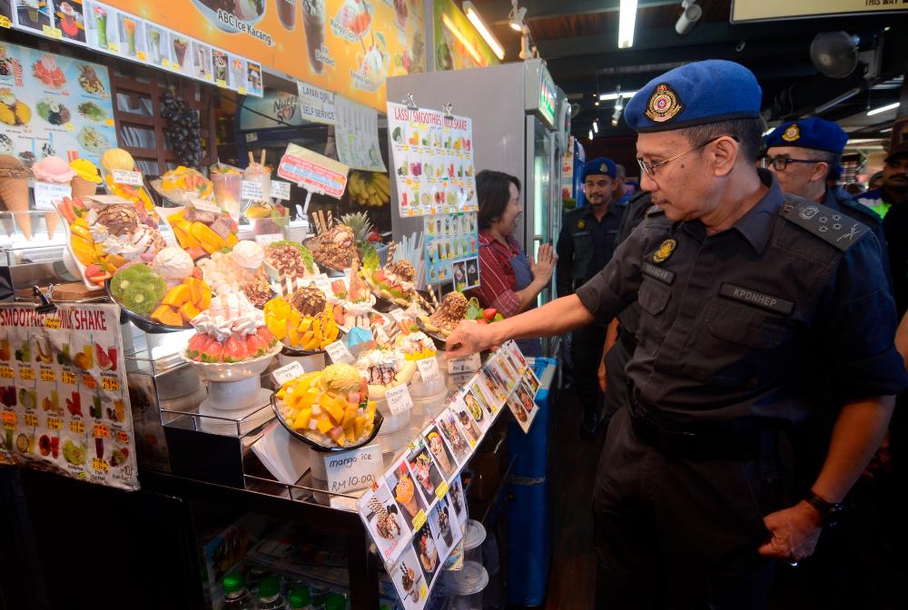 The Domestic Trade and Consumer Affairs Ministry’s enforcement director, Datuk Iskandar Halim Sulaiman, inspects a stall during a Price Compliance Programme (Ops Indah) at Bukit Bendera, on Jan 5, 2019. — Bernama