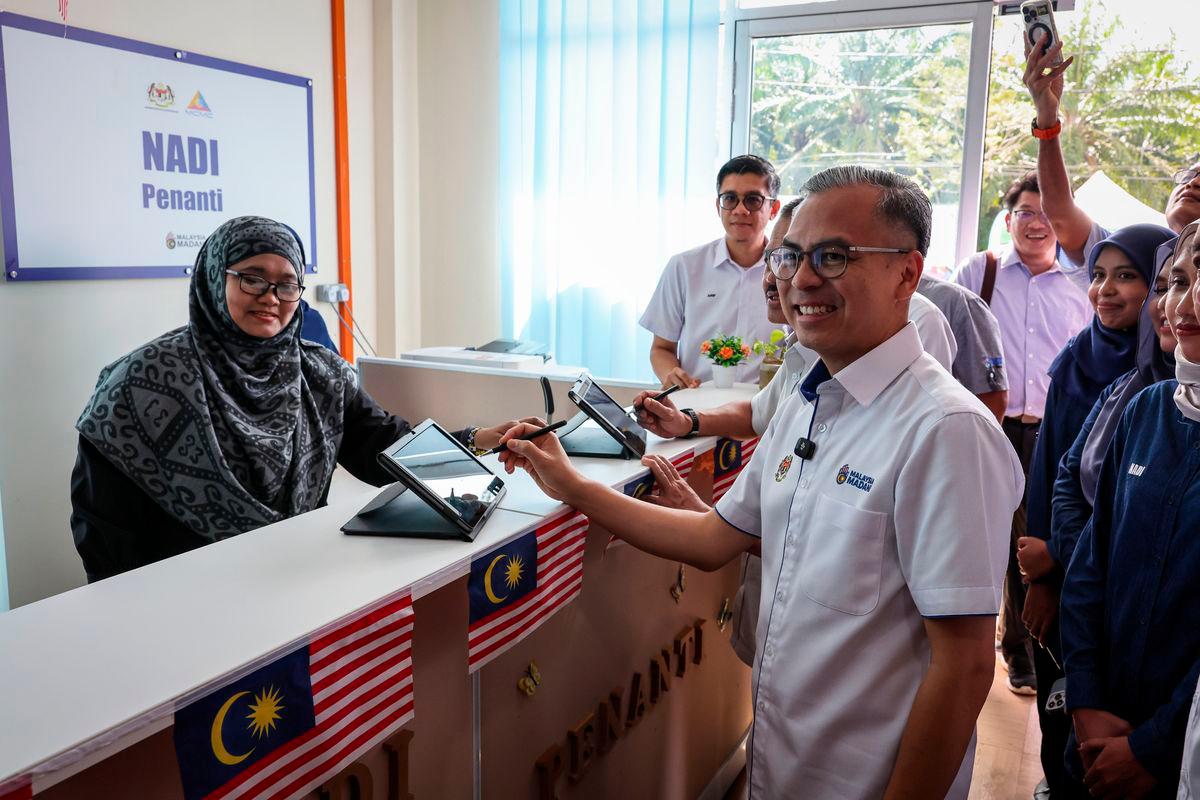 Menteri Komunikasi Datuk Fahmi Fadzil menandatangani kehadiran ketika melakukan lawatan di Pusat Sebaran Maklumat Nasional (NADI) Penanti hari ini - fotoBERNAMA