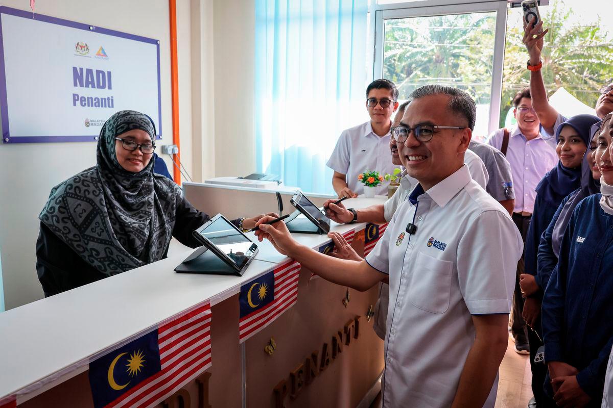 Communications Minister Datuk Fahmi Fadzil signed the attendance during his visit to the National Information Dissemination Centre (NADI) Penanti today. – BERNAMA