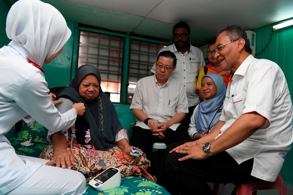 Health Minister Datuk Seri Dr Dzulkefly Ahmad R) and Finance Minister Lim Guan Eng (3rd L) watch as a nurse performs checks on senior citizen Ramlah Hamid, 70, during a community programme organised by the Bagan parliamentary constituency office, on Sept 15, 2019. — Bernama