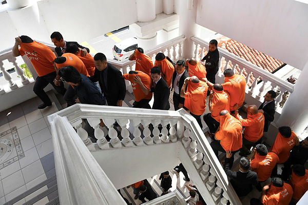 MACC brings 30 detainees, including 24 RTD enforcement officers, to be remanded at the George Town court complex on April 17, 2019. — Bernama