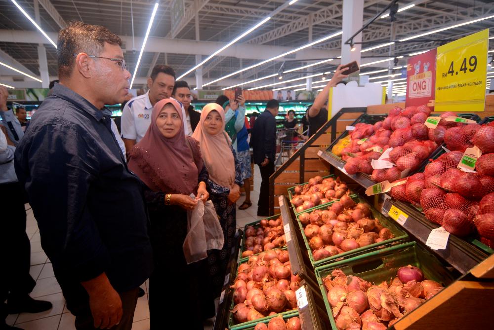 Domestic Trade and Consumer Affairs Minister Datuk Seri Saifuddin Nasution Ismail (L) reviews onion prices after a press conference at Tesco Seberang Jaya yesterday. - Bernama
