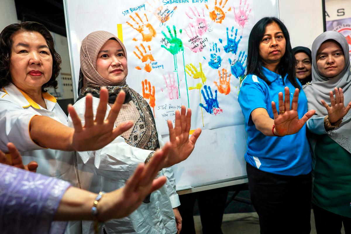 Menteri Pendidikan Fadhlina Sidek (dua, kiri) bergambar dengan poster anti buli pada Kempen Jelajah Anti Buli di Yayasan Aman hari ini. - BERNAMA