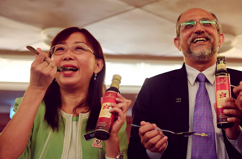 Primary Industries Minister Teresa Kok and Malaysian Palm Oil Board chairman Tan Sri Mohd Bakke Salleh having a taste of Extra Red Palm Fruit Oil during an event to help promote the use of red palm oil among hoteliers and Penang Chef Association members at a hotel in George Town on June 13, 2019. The product is due to be marketed next month. — Bernama