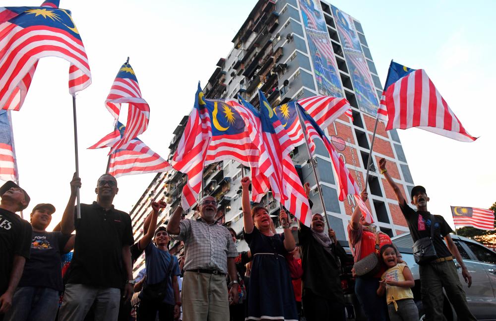 GEORGE TOWN, 22 August — PATRIOTIC SPIRIT... Datuk Seri Salim Abdul Rahman, 54, together with the residents of Kampung Melayu Flats waved the Jalur Gemilang when decorating 3,000 pieces of the Jalur Gemilang around Jalan Kampung Melayu, Air Itam in conjunction with the National Day celebration on This August 31st. BERNAMAPIX