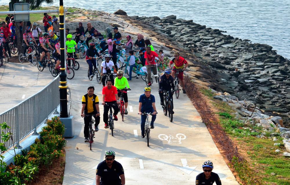 Penang City Council (MBPP) mayor Datuk Yew Tung Seang (C) and others ride their bikes along the coast of Bayan Indah after the ‘Foldies On Rapid’ programme launch on Aug 4, 2019. - Bernama
