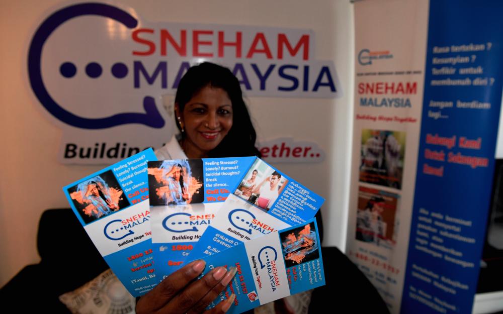 Founder and president of Sneham Malaysia Welfare Association Dr Florance Sinniah holds up some pamphlets at the Sneham Center in Butterworth today. - Bernama