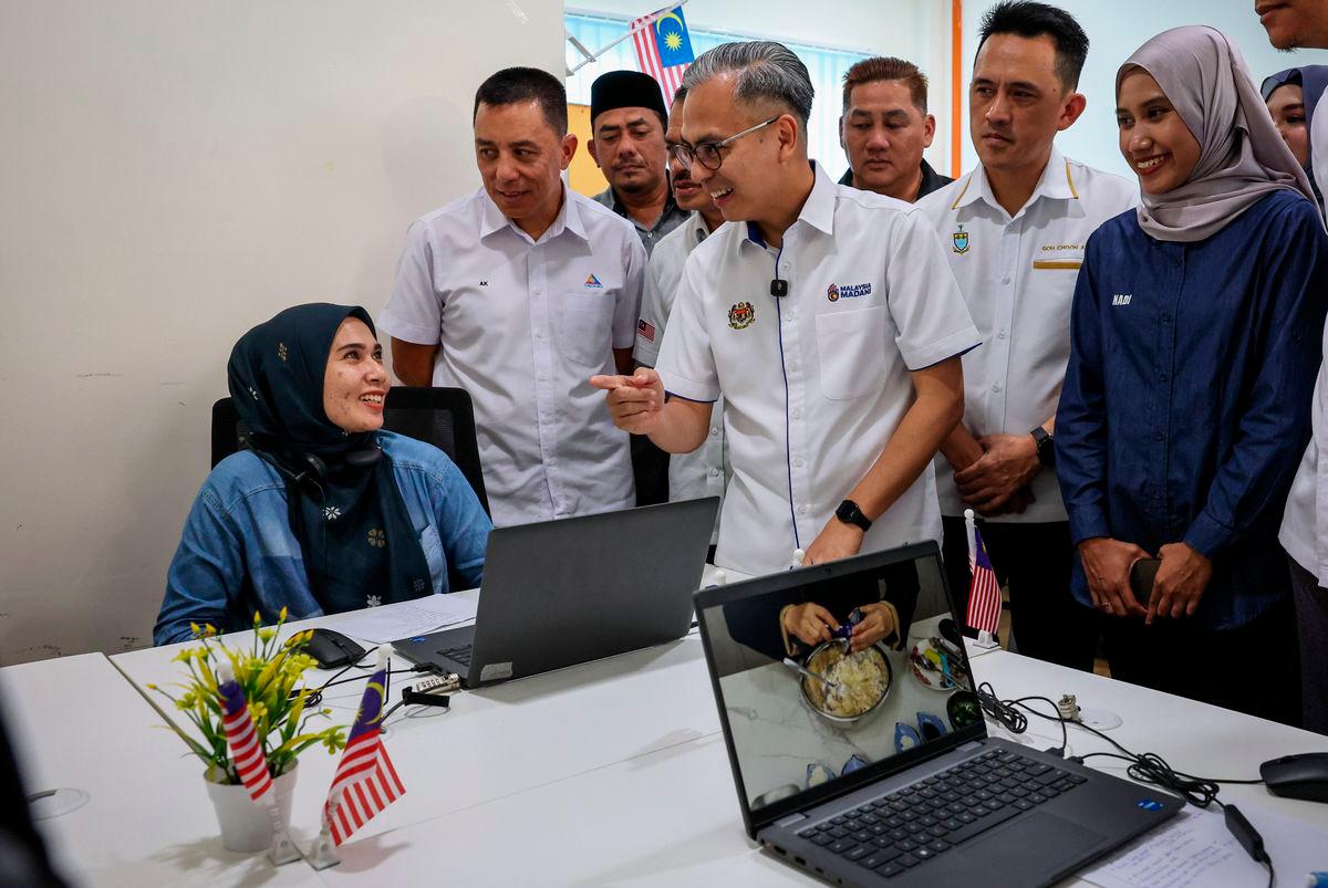 Menteri Komunikasi Datuk Fahmi Fadzil (tengah) beramah mesra dengan komuniti setempat selepas merasmikan Pusat Sebaran Maklumat Nasional (NADI) Penanti hari ini - fotoBERNAMA