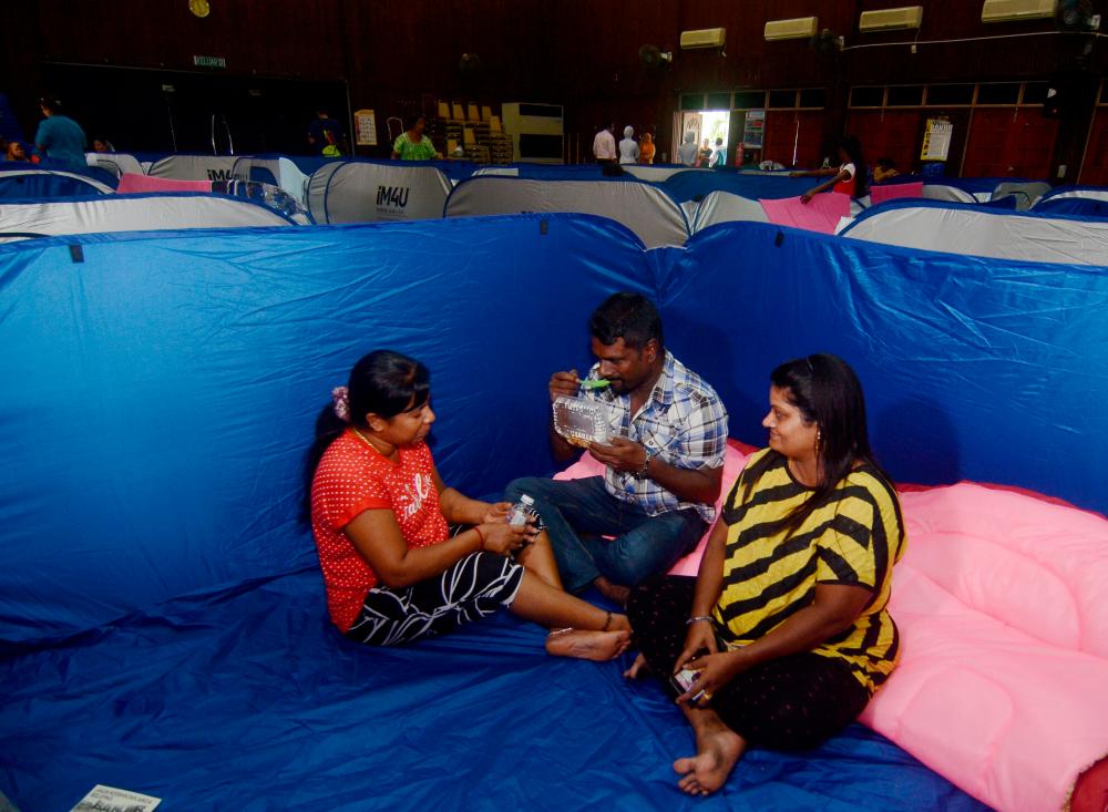 Flood victims S. Mahendran, 48 (C), his wife N. Wanie 45, (R), and her sister M. Loganbal 44, at a flood relieft centre in Jawi, after they had to evacuate their home in Kampung Sethu, on Oct 26, 2019. — Bernama