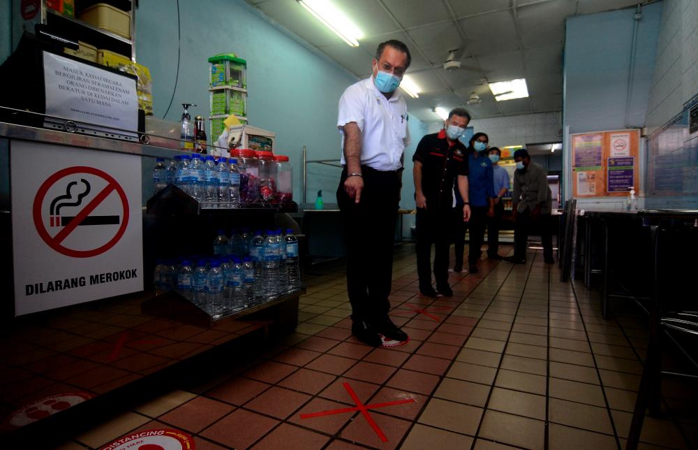 Penang’s Local Government, Housing Development and Town and Country Planning Committee chairman Jagdeep Singh Deo (L), and Penang Island City Council (MBPP) mayor Datuk Yew Tung Seang (2ndL) during a spot check on an eatery in the island, on May 31, 2020. — Bernama