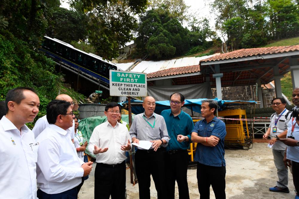 Penang Chief Minister Chow Kon Yeow (3rd from L) reviews the maintenance work being done by the Penang Hill Corporation today. - Bernama