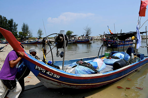 A fisherman pushes a boat into the sea today at Sungai Batu fisherman’s jetty, one of the areas that will be affected by the Penang South Reclamation (PSR) project.
