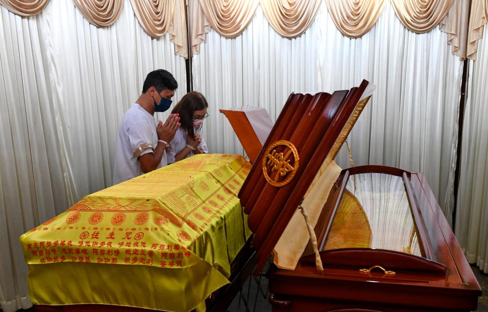 BUKIT MERTAJAM, Feb 10 -- Wong Yunn Wen, 42, (second, left) and his younger brother Wong Chia Hao, 41, pay their last respects to their late mother, Ang Meng Hoong, 62, and their late aunt, Lee Moy, 67, at his residence is Machang Bubok today. BERNAMAPIX