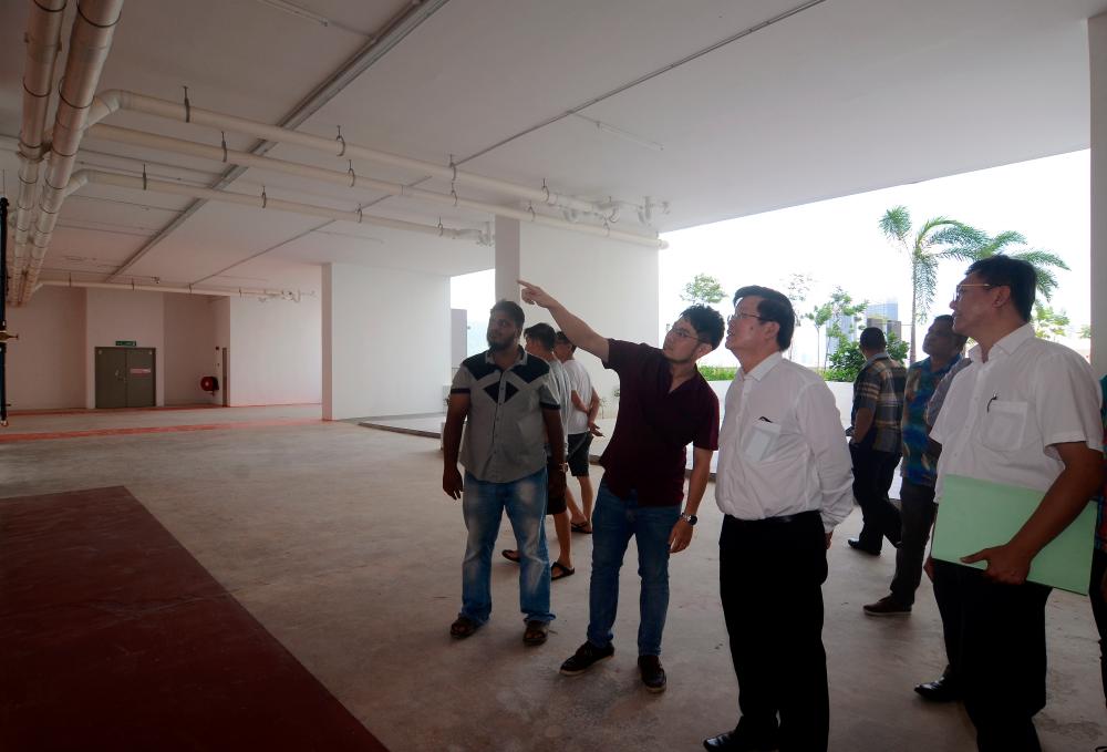 Residents point out defects at the condominium to Penang Chief Minister, Chow Kon Yeow, on Oct 12, 2019. — Bernama