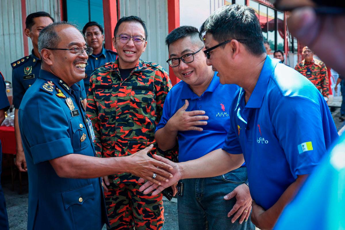 Deputy Director-General (Operations) of the Malaysian Fire and Rescue Department (JBPM), Datuk Ahmad Izram Osman, shakes hands with volunteer firefighters during the Launch Ceremony of the JBPM Water Activity Safety Council Centre of Excellence at the Fire Department Marine Unit Base in Mak Mandin today. – BERNAMA