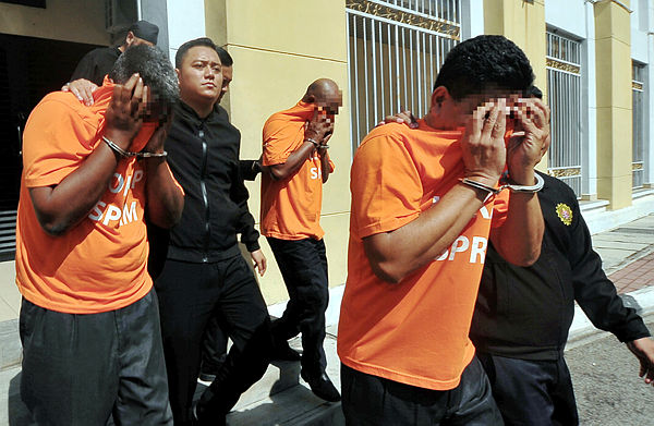 MACC personnel escort the government agency deputy director and two lower level personnel, who have been remanded for five days to assist in investigations. — Bernama
