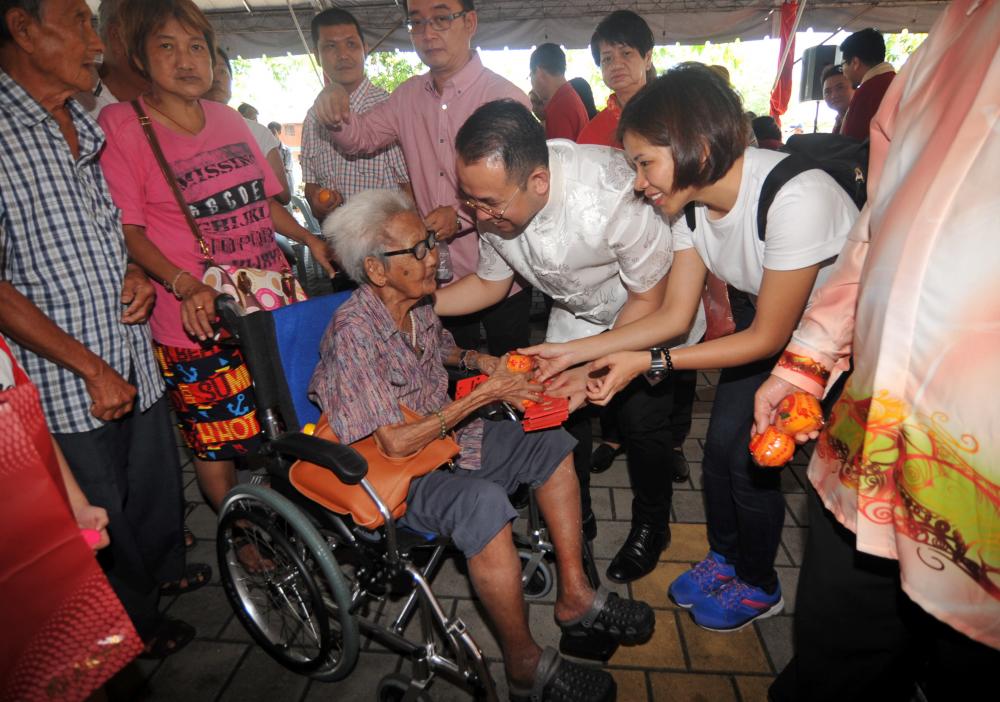 Deputy Minister of Youth and Sports, Steven Sim Chee Keong (2R) presents donations to some of the 500 underprivileged in the Bukit Mertajam parliamentary constituency at the Chinese New Year Charity Program, on Feb 10, 2019. — Bernama