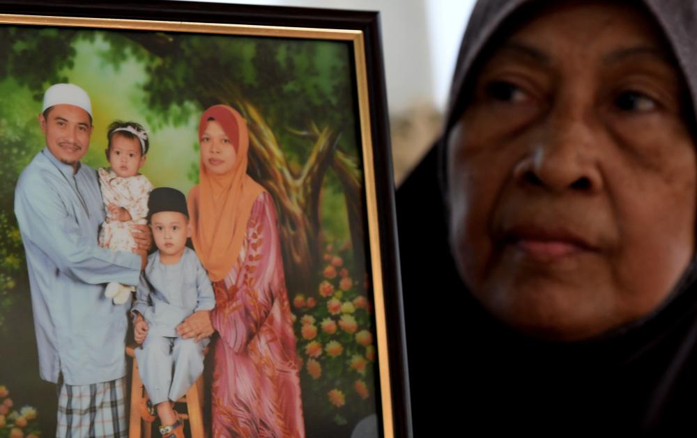 Rokiah Mohammad, 65, shows a picture of her son’s family Rahimi Ahmad, victim of a mosque attack in New Zealand, at her home in Kampung Permatang Binjai Bayan Lepas, on March 15, 2019. — Bernama