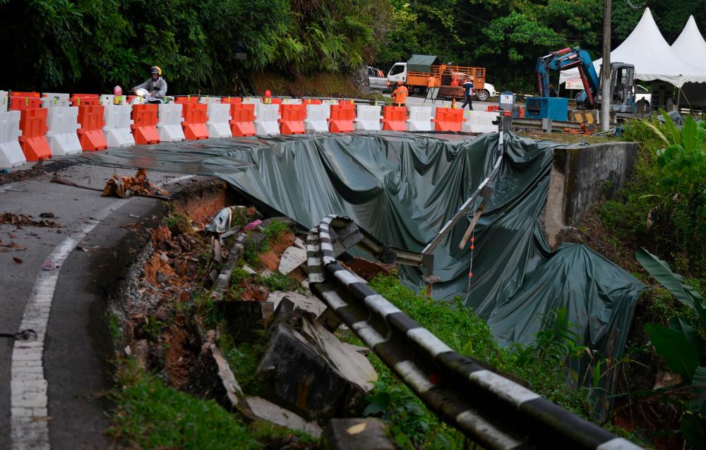 BALIK PULAU, 27 Julai -- Jalan raya Laluan FT006 Jalan Balik Pulau-Teluk Bahang terputus hubungan akibat kejadian tanah runtuh. fotoBERNAMA