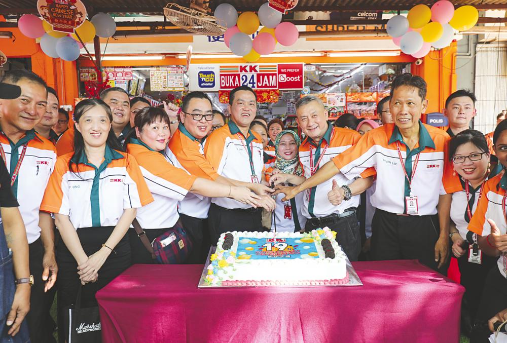 Fifth from left: KK Group founder and group executive chairman Datuk K.K. Chai cutting the anniversary cake flanked by the management team of KK Super Mart. – ASYRAF RASID/THESUN
