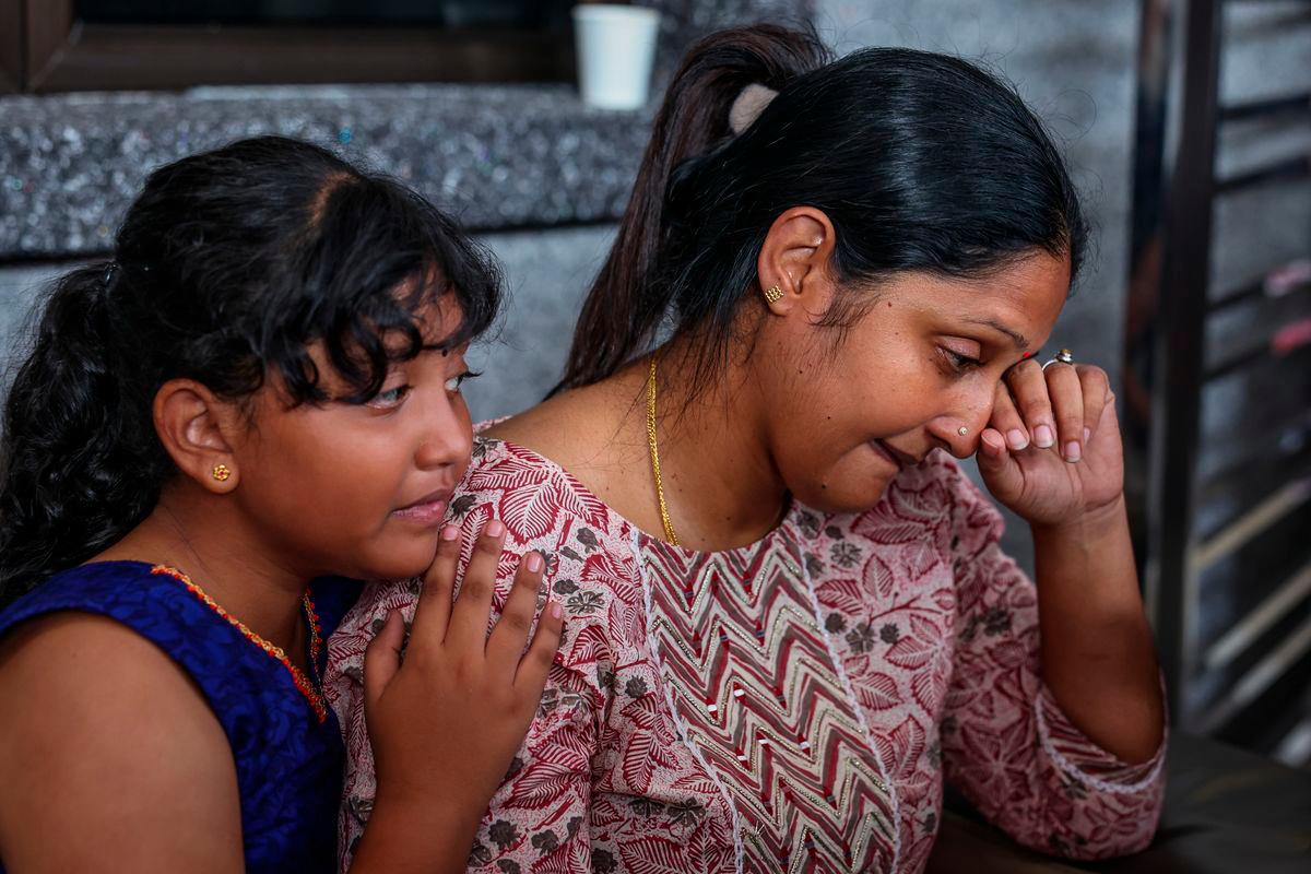 S. Sanggetha, 39, and her eldest daughter A. Hirsshika, 9, were overcome with emotion as they paid their last respects to the late S. Arumugam, 40, and their daughter A. Sarrvihka, 3, at their home near Taman Bayu Aman today. Photo by BERNAMA