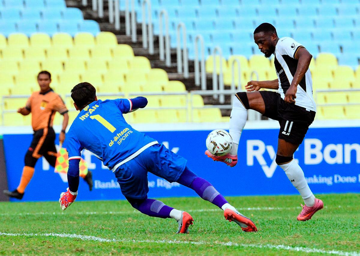 Terengganu FC player Yann Kevin Mabella (right) controls the ball against Imigresen FC goalkeeper Muhammad Zarif Irfan Hashimuddin during the FA Cup match at the Penang State Stadium here today. - BERNAMA