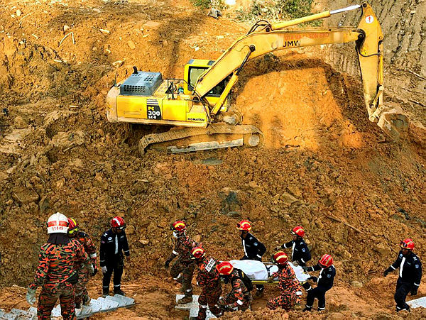 Filepix taken on Oct 22, 2018 shows Fire and Rescue personnel carrying the remains of a victim of the landslide at Jalan Bukit Kukus last year.
