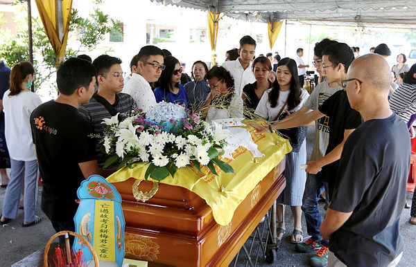 Family and friends of accident victim Moey Yun Peng pay their last respects at the Berapit Chinese cemetery,Bukit Mertajam, Penang. — BBXpress