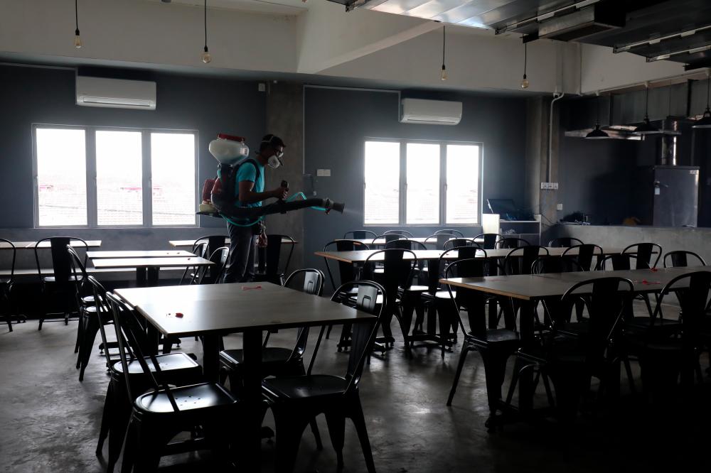 $!Sanitation and disinfection work being carried out at an eatery in Klang yesterday. – ASYRAF RASID/THESUN