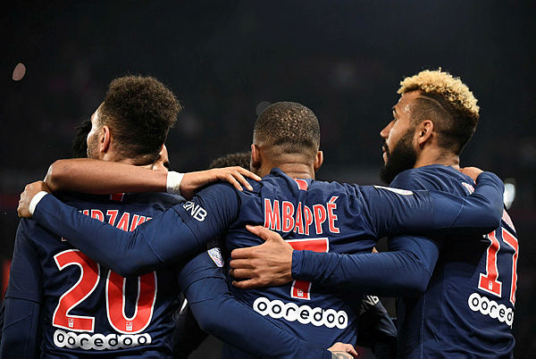 Paris Saint-Germain’s (PSG) French forward Kylian Mbappe celebrates with PSG’s French defender Layvin Kurzawa (L), and PSG’s Cameroonian forward Eric Choupo-Moting (R) after scoring a goal during the French L1 football match between PSG and Montpellier (MHSC) at the Parc des Princes stadium — AFP