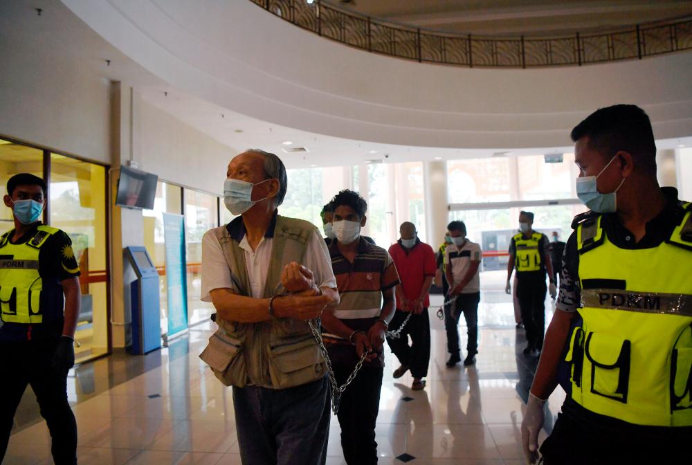 An 81-year-old Japanese citizen and nine other individuals enter the Kuantan magistrate’s court to be charged for violating the MCO. - Bernama
