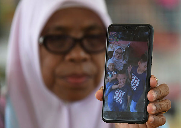 Salmah Abdullah, 58, shows a picture of Surawati Mohd, 33, who died with her husband Muhammad Noor Idham Ramli, 31, after an accident at KM134 of Jalan Kuantan-Seremban yesterday. — Bernama