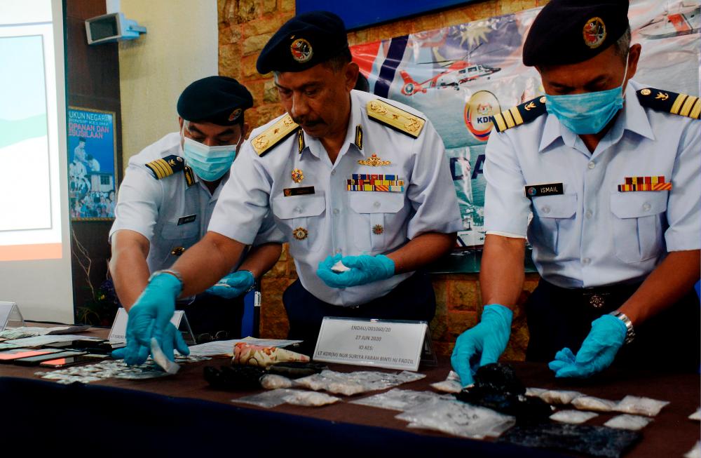 Pahang APMM director Marine First Admiral Amran Daud (C) and his staff display drugs and other evidence seized, during a press conference at the Pahang APMM headquarters today. - Bernama