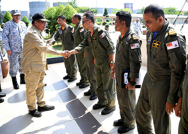 Defence Minister Mohamad Sabu (two, left) greets pilots at the Wilayah Laut 1 navy Headquarters in Tanjung Gelang, on July 16.