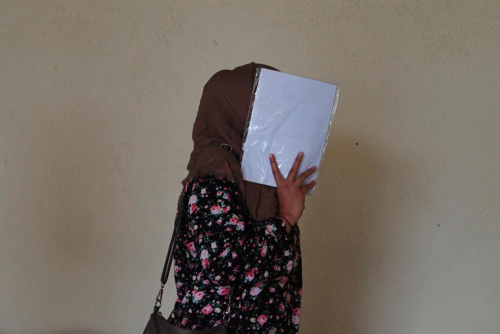 Nurul Rohaizaz Farhana Syuhada Zazli hides her face when entering the Raub sessions court on Sept 29, 2019. - Bernama