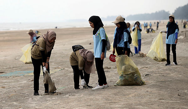 Volunteers pick up garbage at Pantai Sepat today. — Bernama