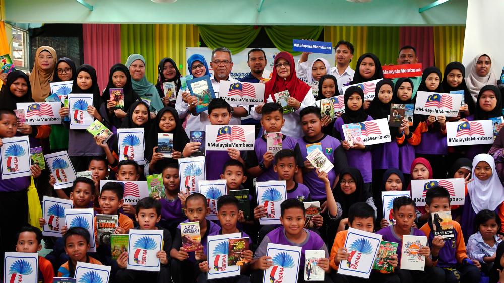 Chief Librarian at the Resource Centre of the Communications and Multimedia Ministry, Hashimah Mohd Yusof (back eight, right) and SK Sungai Lembing headmaster Mohd Shari Muda with students in conjunction with the ‘Kasih: Books4U’ programme at SK Sungai Lembing on Oct 26, 2019. - Bernama